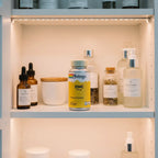 Solaray Zinc 50mg bottle inside organized white wooden medicine cabinet with premium apothecary containers and soft interior shelf lighting