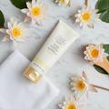 Mary Kay Satin Body Revitalizing Shea Scrub Fresh Waterlily spa flat lay with waterlily flowers and white towel