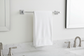 Delta Ara 18-inch polished chrome towel bar mounted on white bathroom wall with folded white towel — modern minimalist bathroom decor