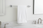 Delta Ara 18-inch polished chrome towel bar mounted on white bathroom wall with folded white towel — modern minimalist bathroom decor