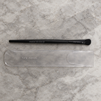 AI image of Mary Kay All-Over Eye Shadow Brush and sleeve on pale stone