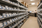 Organized workshop shelving holding genuine replacement appliance components in sealed packages