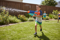 Nerf Super Soaker Power Drench kid firing water blaster on sunny backyard lawn