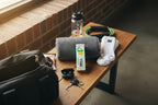 Organized gym bag essentials on a wooden bench with Will Relieve pain relief roll-on bottle visible in natural light
