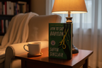 How to Say Babylon by Safiya Sinclair hardcover on wooden side table with cup of tea and reading lamp – More4less Outlet