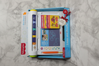 Fisher-Price Learn and Doodle Desk gift flatlay on white marble with retail box stencils and stylus - More4less Outlet