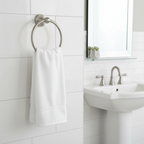 Pfister Redmond towel ring holding a white hand towel beside a bathroom mirror