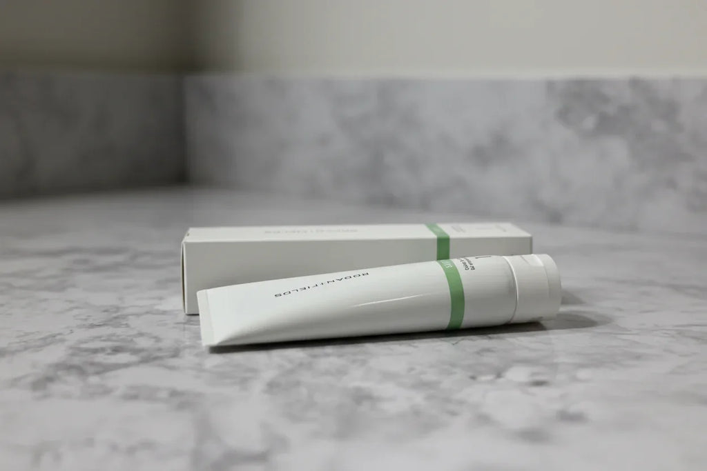 Minimalist professional bathroom setup with Rodan + Fields SOOTHE Calming Gel Cleanser tube and box on stone vanity