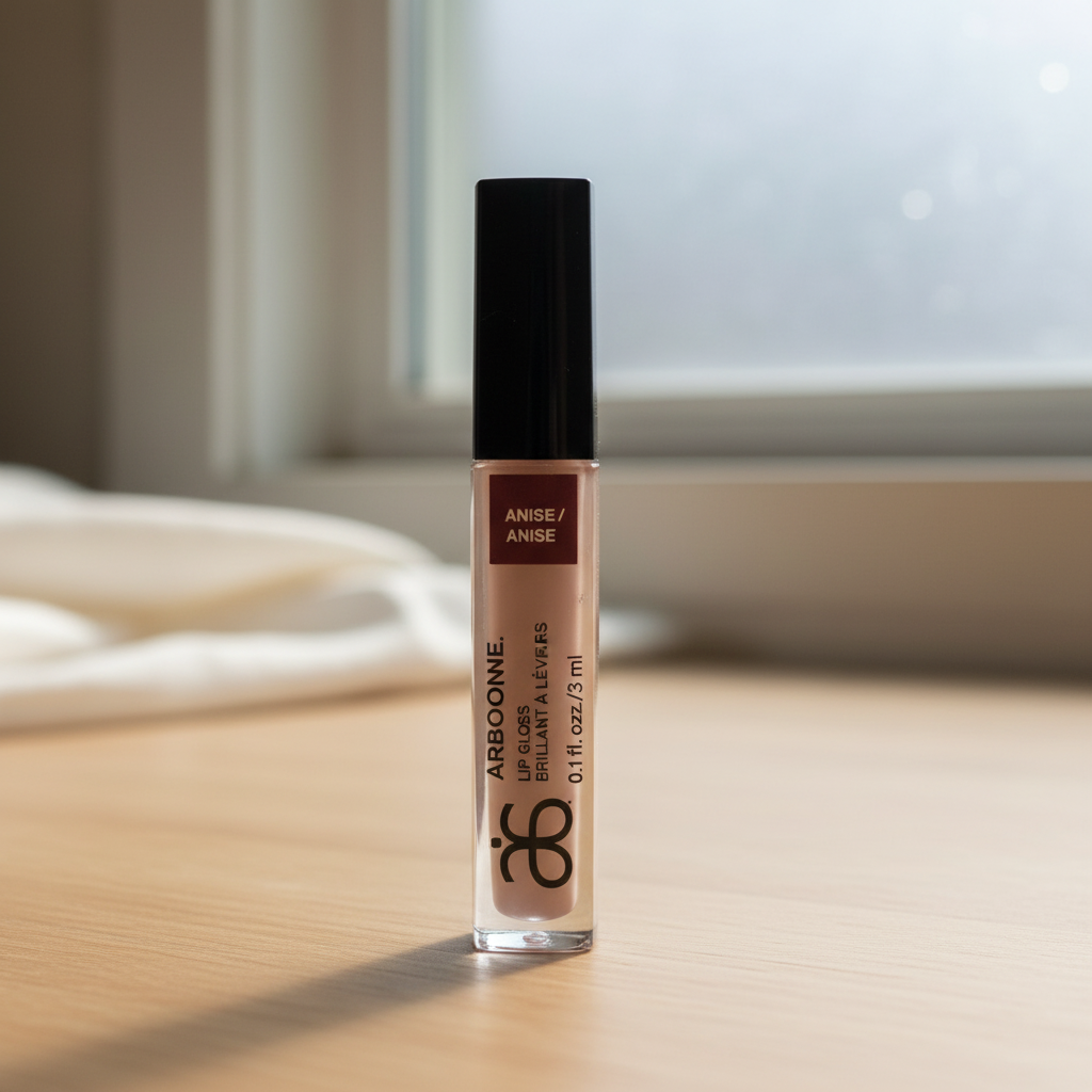 Arbonne Glossed Over Lip Gloss in Anise 0.1 fl oz on a clean makeup vanity