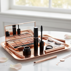 Elegant cosmetic setup on rose-gold vanity tray with glossy black mascara tube standing upright alongside premium eye makeup products