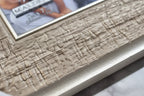 Close-up macro of frame surface showing horizontal ribbed textural relief and metallic wash finish