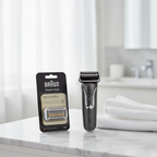 Electric shaver replacement head in black packaging beside sleek razor and white towel on white marble bathroom counter – More4less Outlet