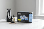 Professional male grooming station featuring electric shaver maintenance supplies on a clean marble vanity