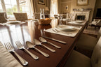 Classic household setting showcasing bright high-polish mirror finish dining cutlery on dark wood table