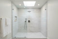 Luxury modern bathroom walk-in shower with polished chrome shower head on marble subway tile