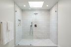Luxury modern bathroom walk-in shower with polished chrome shower head on marble subway tile