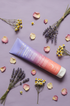 Pacifica Lavender Moon Body Lotion flat lay on purple background with lavender bundles rose petals and chamomile