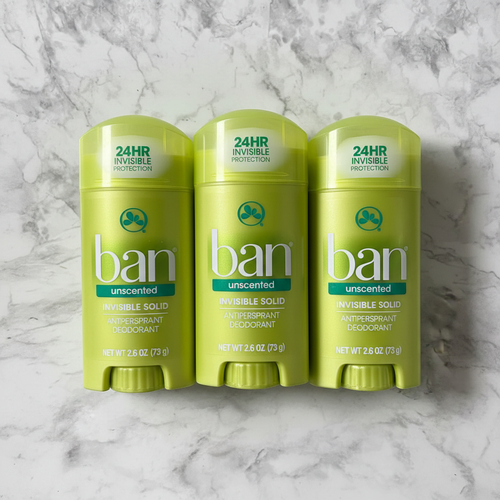 Five lime-green Ban Unscented solid deodorant sticks on white marble