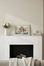 Malden silver glitter diamond picture frame holding family portrait on modern white fireplace mantle, warm interior lighting