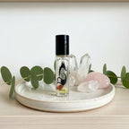 Vixen Skincare crystal elixir roller bottle in minimalist wellness setting with eucalyptus and natural crystals.
