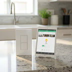 Quirky + GE Tapt Smart Switch on grey granite countertop next to tablet showing home automation app interface under bright afternoon light