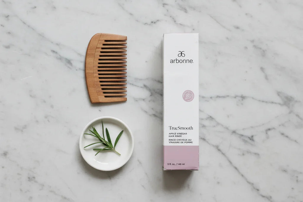 Arbonne TrueSmooth Apple Vinegar Hair Rinse hair care flat lay on neutral stone surface