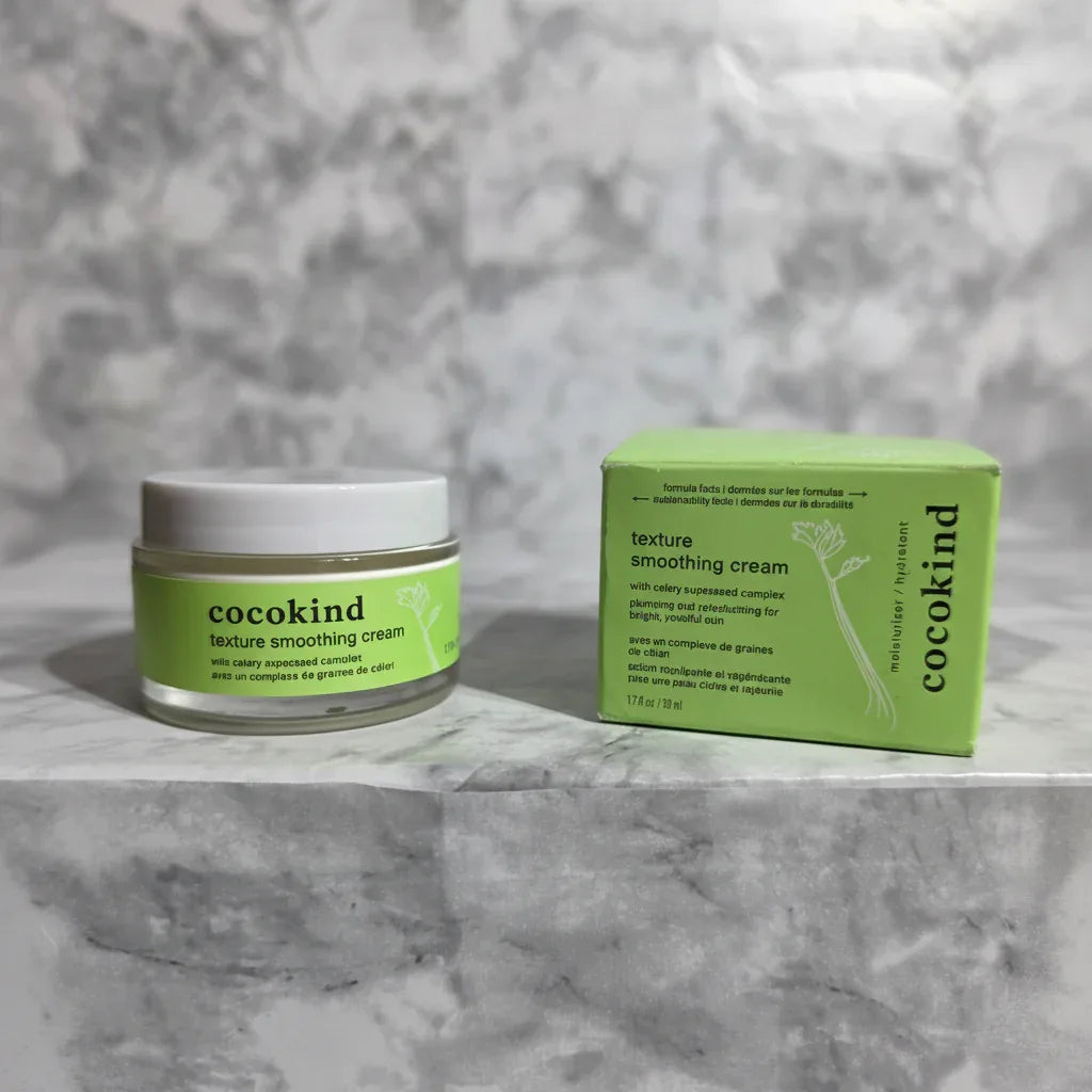 Modern clean skincare composition showcasing green label moisturizer cream jar and box on soft white marble surface