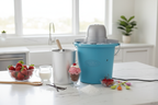 Nostalgia 4-quart blue electric ice cream maker on modern kitchen island surrounded by fresh strawberries cream and vanilla