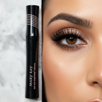 Lifestyle beauty scene showing beautifully lengthened, separated, and defined lashes with rich black mascara, with the Mary Kay Lash Love Lengthening Mascara glossy black tube with pink branding resting on a marble surface