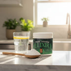 Dan's Morning Elixir white wellness powder on wooden spoon with glass of water and lemon slice on marble breakfast bar