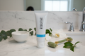 Rodan + Fields REDEFINE Rejuvenation Mask white tube on marble vanity with jade roller white bowl and fresh botanicals premium skincare – More4less Outlet