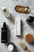 Rodan + Fields Densifying+ Treatment on organized vanity area with luxury haircare products and minimalist stone background