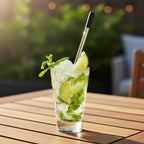 Undici chiller swizzle stick in highball mojito glass with fresh mint and lime on sunlit wooden outdoor deck table