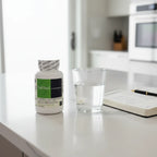 DaVinci Laboratories NAC 500mg bottle on white quartz kitchen island with clear glass of water and daily health journal