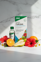 Salus Floradix Calcium Liquid Mineral Formula 250ml retail box on a marble surface with hibiscus flowers, chamomile, pear, and orange – More4less Outlet