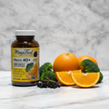 MegaFood Men's 40+ One Daily amber glass bottle beside fresh organic oranges broccoli and elderberries on white marble – More4less Outlet