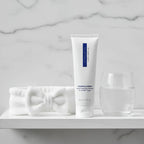 ZO Medical Foamacleanse travel cleanser on white bathroom shelf with skincare headband and water glass luxury bath aesthetic