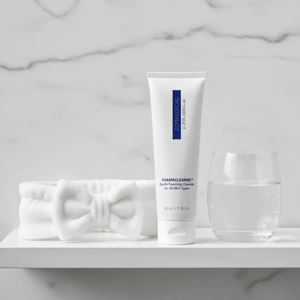 ZO Medical Foamacleanse travel cleanser on white bathroom shelf with skincare headband and water glass luxury bath aesthetic