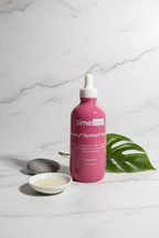 Minimal professional skincare arrangement showcasing a premium large format pink glass serum bottle on white marble in soft clean lighting