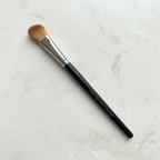 Mary Kay Cream Eye Color and Concealer Brush on a light stone surface