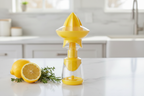 Core Kitchen yellow citrus juicer and mister set on white kitchen counter with halved lemon and fresh herbs — all-in-one citrus tool for everyday cooking