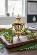 Baldwin 0102 Colonial Door Knocker Polished Brass on walnut oak board with greenery home upgrade design