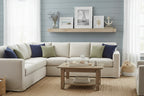 Coastal farmhouse living room staging with distressed white textural leaf-pattern decor frames
