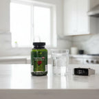 Irwin Naturals Prosta-Strong RED bottle on white quartz breakfast bar with glass of water and fitness tracker