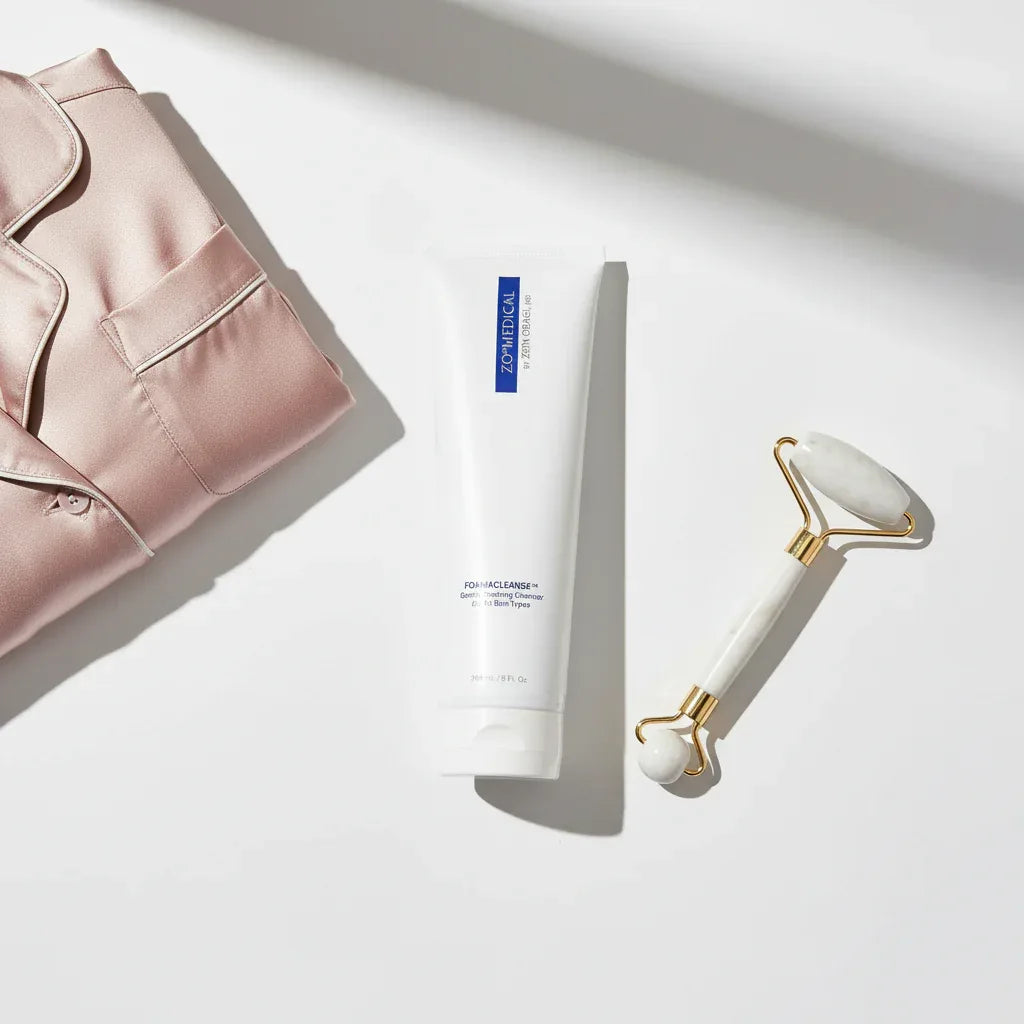 ZO Medical Foamacleanse skincare flat-lay with silk pajamas and marble facial massager