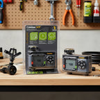 Melnor XT HydroLogic Digital Water Timer on contemporary workbench inside well-lit workshop alongside lawn sprinklers for seasonal prep