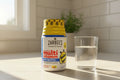 Zarbee's Children's Multivitamin jar on bright kitchen counter with morning sunlight and glass of water