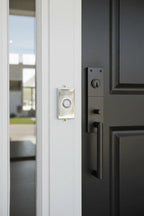 Baldwin Contemporary Doorbell Button Chrome mounted on modern white exterior home-trim frame