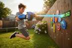 Gelbee Flurry Glove Gel BB Blaster worn by teen firing in sunny backyard action scene — More4less Outlet