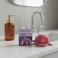 Joy 5-Blade Razor Refills 8ct on white quartz vanity top with amber glass dispenser and fresh peony